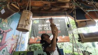 Anggota Komunitas Ciliwung Depok (KCD)  saat membuat kerajinan tangan dengan menggunakan bambu bekas di sekitar kawasan bantaran Sungai Ciliwung, Depok Jawa Barat, Jum'at (25/1). [Suara.com/Fakhri Hermansyah]