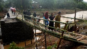 Warga melewati jembatan darurat sementara yang terbuat dari bambu di desa Pallatikang, Kabupaten Gowa, Sulawesi Selatan, Kamis (24/1). ANTARA FOTO/Abriawan Abhe