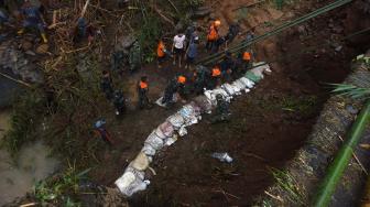 Tim SAR Gabungan berusaha membuat tanggul di sungai Manuju yang amblas akibat longsor di Desa Pattilasang, Kecamatan Manuju, Gowa, Sulawesi Selatan, Jumat (25/1). ANTARA FOTO/Yusran Uccang