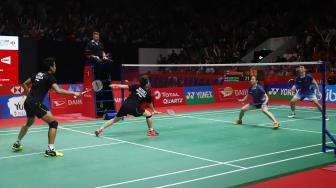 Pebulu tangkis ganda campuran Indonesia Liliyana Natsir dan Tontowi Ahmad saat berusaha mengembalikan kok ke ganda campuran Cina Zheng Siwei dan Huang Yaqiong pada pertandingan final Daihatsu Indonesia Masters 2019 di Istora Senayan, Jakarta, Minggu (27/1). [Suara.com/Muhaimin A Untung]