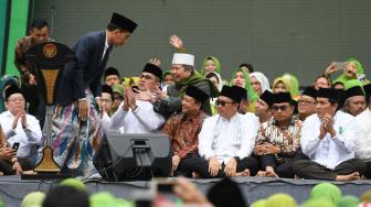 Presiden Joko Widodo membungkukkan badan seusai memberikan sambutan pada Harlah ke-73 Muslimat Nahdlatul Ulama (NU), doa bersama untuk keselamatan bangsa dan maulidrrasul di Stadion Utama Gelora Bung Karno, Jakarta, Minggu (27/1). ANTARA FOTO/Wahyu Putro A