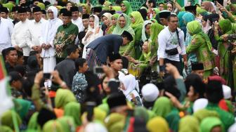 Presiden Joko Widodo (tengah) menyalami Istri almarhum Gus Dur Sinta Nuriyah saat menghadiri Harlah ke-73 Muslimat Nahdlatul Ulama (NU), doa bersama untuk keselamatan bangsa dan maulidrrasul di Stadion Utama Gelora Bung Karno, Jakarta, Minggu (27/1). ANTARA FOTO/Wahyu Putro A