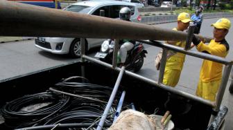 Petugas Bina Marga Jakarta Selatan melakukan penertiban jaringan kabel utilitas yang semrawut di kawasan Warung Jati Barat, Jakarta Selatan, Rabu (30/1).[Suara.com/Fakhri Hermansyah]
