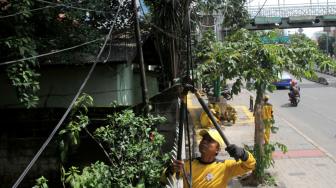 Petugas Bina Marga Jakarta Selatan melakukan penertiban jaringan kabel utilitas yang semrawut di kawasan Warung Jati Barat, Jakarta Selatan, Rabu (30/1).[Suara.com/Fakhri Hermansyah]
