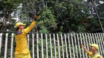 Petugas Bina Marga Jakarta Selatan melakukan penertiban jaringan kabel utilitas yang semrawut di kawasan Warung Jati Barat, Jakarta Selatan, Rabu (30/1).[Suara.com/Fakhri Hermansyah]
