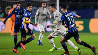 Pemain depan Juventus Cristiano Ronaldo mencoba melewati bek Atalanta Albania Berat Djimsiti selama pertandingan lanjutan Coppa Italia antara Atalanta melawan Juventus di Stadion Atleti Azzuri d'Italia, Bergamo, Italia, Kamis (31/1) dini hari WIB. [Miguel MEDINA / AFP]