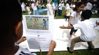 Seorang siswa memperhatikan gambar permainan Gobak Sodor/Galasin di lapangan Wali Kota Depok, Jawa Barat, Sabtu (2/2).  [ANTARA FOTO/Kahfie Kamaru]