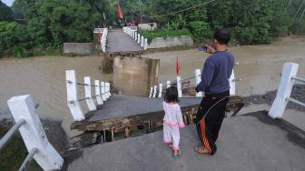 Sejumlah warga berada di dekat patahan jembatan yang ambruk di Repaking, Wonosegoro, Boyolali, Jawa Tengah, Sabtu (2/2). [ANTARA FOTO/Aloysius Jarot Nugroho]