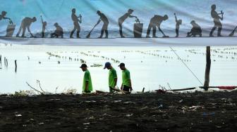 Relawan dari Invest Co-op Indonesia memungut sampah saat melakukan Aksi Pantai Kami Bersih di Pantai Ujung Baji, Takalar, Sulawesi Selatan, Sabtu (2/2). ANTARA FOTO/Yusran Uccang