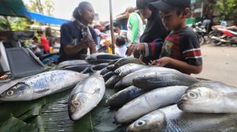 Warga membeli ikan bandeng di Pasar Rawa Belong, Jakarta, Minggu (3/1). [Suara.com/Muhaimin A Untung]