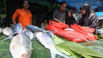 Warga membeli ikan bandeng di Pasar Rawa Belong, Jakarta, Minggu (3/1). [Suara.com/Muhaimin A Untung]