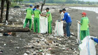 Relawan dari Invest Co-op Indonesia memungut sampah saat melakukan Aksi Pantai Kami Bersih di Pantai Ujung Baji, Takalar, Sulawesi Selatan, Sabtu (2/2). ANTARA FOTO/Yusran Uccang