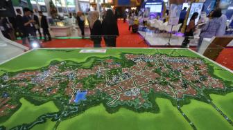 Pengunjung melintas di dekat maket sebuah apartemen pada Indonesia Property Expo (IPEX) 2019 di Jakarta Convention Centre (JCC), Jakarta, Senin (4/2). [Suara.com/Muhaimin A Untung]