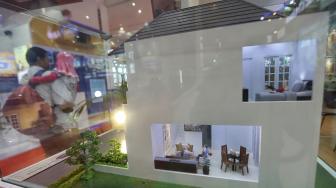 Pengunjung melintas di dekat maket sebuah rumah pada Indonesia Property Expo (IPEX) 2019 di Jakarta Convention Centre (JCC), Jakarta, Senin (4/2). [Suara.com/Muhaimin A Untung]