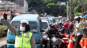 Polisi mengatur lalu lintas untuk mengurai antrean kendaraan menuju kawasan Puncak, Gadog, Bogor, Jawa Barat, Selasa (5/2). [ANTARA FOTO/Yulius Satria Wijaya]