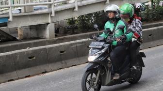 Pengendara sepeda motor menggunakan aplikasi GPS (pelacak jalan) saat berkendara di kawasan manggarai, Jakarta, Jumat (8/2). [Suara.com/Muhaimin A Untung]