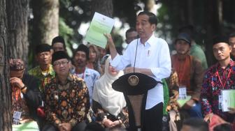 Presiden Joko Widodo menunjukkan Surat Keputusan tentang Pengelolaan Hutan Sosial saat berpidato di Wana Wisata Pokland Haurwangi, Cianjur, Jumat (8/2). [ANTARA FOTO/Akbar Nugroho Gumay]