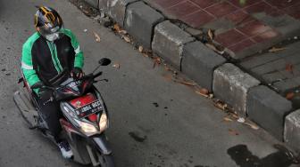 Pengendara sepeda motor menggunakan aplikasi GPS (pelacak jalan) saat berkendara di kawasan manggarai, Jakarta, Jumat (8/2). [Suara.com/Muhaimin A Untung]