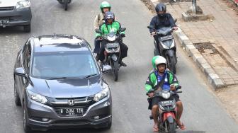 Pengendara sepeda motor menggunakan aplikasi GPS (pelacak jalan) saat berkendara di kawasan manggarai, Jakarta, Jumat (8/2). [Suara.com/Muhaimin A Untung]