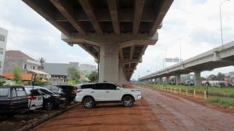 Sejumlah mobil terparkir di bawah kolong tol Becakayu Kalimalang, Jakarta Timur, Sabtu (9/2).[Suara.com/Fakhri Hermansyah]