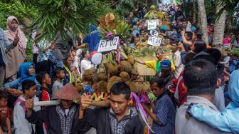 Sejumlah warga bergotong royong memikul gunungan durian saat Festival Durian Lolong di Desa Lolong, Karanganyar, Kabupaten Pekalongan, Jawa Tengah, Sabtu (9/2). [ANTARA FOTO/Harviyan Perdana Putra]