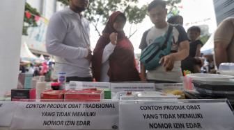 Petugas Badan Pengawasan Obat dan Makanan (BPOM) mensosialisasikan kepada warga jenis makanan dan produk kosmetik saat peringatan HUT ke-18 BPOM di Sarinah, MH Thamrin, Jakarta, Minggu (10/2). [Suara.com/Muhaimin A Untung]