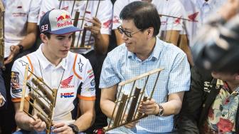 Executive Vice President Director AHM Johannes Loman (kanan) bermain angklung bersama Pebalap MotoGP Marc Marquez (kiri), saat kunjunga di Saung Angklung Udjo, Bandung, Jawa Barat, Minggu (10/2). [ANTARA FOTO/M Agung Rajasa]