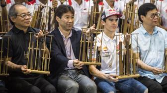 
President Director AHM Toshiyuki Inuma (kiri), Executive Vice President Director Johannes Loman (kanan), General Manager Race Operations Management Division Tetsuhiro Kuwata (kedua kiri) dan Pebalap MotoGP Marc Marquez (kedua kanan) memainkan angklung saat kunjungan di Saung Angklung Udjo, Bandung, Jawa Barat, Minggu (10/2). [ANTARA FOTO/M Agung Rajasa]