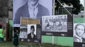 Pengunjung mengamati pameran foto sejarah MH Thamrin, Politik, dan sepak bola kebangsaan di Stadion Vij, Cideng, Jakarta Pusat, Sabtu (16/2). [Suara.com/Fakhri Hermansyah]