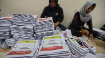 Petugas melipat surat suara di Gudang logistik KPU Komplek Pergudangan Zoodia, Jakarta, Minggu (17/2). [Suara.com/Muhaimin A Untung]