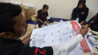 Petugas melipat surat suara di Gudang logistik KPU Komplek Pergudangan Zoodia, Jakarta, Minggu (17/2). [Suara.com/Muhaimin A Untung]