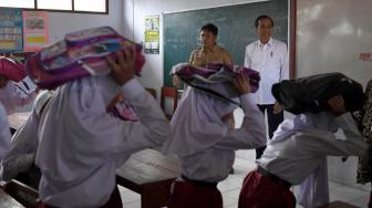 Presiden Joko Widodo (kanan) meninjau simulasi terjadinya gempa bumi saat menghadiri Program Tagana Masuk Sekolah dan Kampung Siaga Bencana di SDN Panimbang Jaya 1, Pandeglang, Banten, Senin (18/2). ANTARA FOTO/Puspa Perwitasari