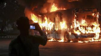 Warga mengabadikan bus Transjakarta berbahan bakar gas yang terbakar di jalan Pos Besar, Pasar Baru, Jakarta, Senin (18/2). [ANTARA FOTO/Muhammad Adimaja]