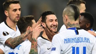 Gelandang Inter Milan Matteo Politano merayakan golnya dengan rekan setimnya setelah mencetak gol keempatnya selama pertandingan leg kedua babak 32 besar Liga Europa antara Inter Milan melawan Rapid Vienna di Stadion Guiseppe Meazza, Milan, Italia, Jumat (22/2) dini hari WIB. [Miguel MEDINA / AFP]