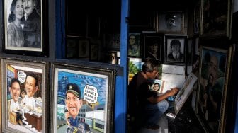 Pelukis sedang berada di kios Sentra Lukisan di kawasan Pasar Baru, Jakarta, Jumat (22/2). [Suara.com/Muhaimin A Untung]