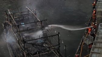 Sejumlah petugas pemadam kebakaran memadamkan api pada salah satu kapal nelayan yang terbakar di Pelabuhan Muara Baru, Jakarta, Sabtu (23/2/2019).