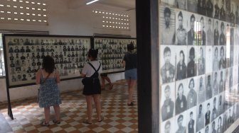 Wisatawan melihat foto-foto korban kekejaman rezim Khmer Merah di Museum Genosida Tuol Sleng, Phnom Penh, Kamboja, Sabtu (23/2). ANTARA FOTO/Nyoman Budhiana