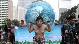 Sejumlah Aktivis melakukan aksi teatrikal bertemakan lingkungan pada Hari bebas kendaraan bermotor (HBKB)  di Bundaran HI, Jakarta Pusat , Minggu (24/2). (Suara.com/Fakhri Hermansyah)