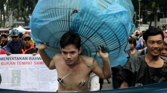 Sejumlah Aktivis melakukan aksi teatrikal bertemakan lingkungan pada Hari bebas kendaraan bermotor (HBKB)  di Bundaran HI, Jakarta Pusat , Minggu (24/2). (Suara.com/Fakhri Hermansyah)