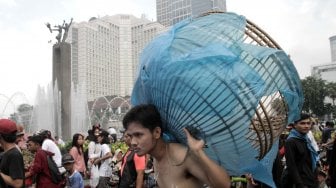 Sejumlah Aktivis melakukan aksi teatrikal bertemakan lingkungan pada Hari bebas kendaraan bermotor (HBKB)  di Bundaran HI, Jakarta Pusat , Minggu (24/2). (Suara.com/Fakhri Hermansyah)