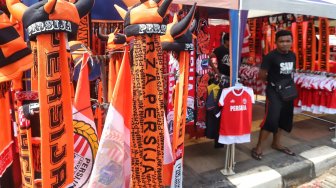 Warga membeli pernak-pernik Persija untuk mendukung Persija di kawasan Gelora Bung Karno, Jakarta, Selasa (26/2). [Suara.com/Muhaimin A Untung]