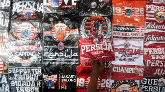 Warga membeli pernak-pernik Persija untuk mendukung Persija di kawasan Gelora Bung Karno, Jakarta, Selasa (26/2). [Suara.com/Muhaimin A Untung]