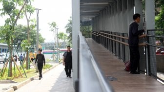 Warga melintas di sekitar Jembatan Penyeberangan Orang (JPO) di kawasan Senayan, Jakarta, Rabu (27/2). [Suara.com/Arief Hermawan P]