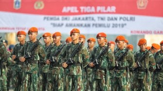 Sejumlah personel gabungan mengikuti apel tiga pilar di Silang Monas, Jakarta, Rabu (27/2). [Suara.com/Muhaimin A Untung]