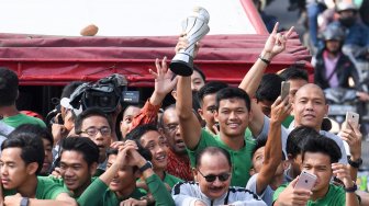 Pemain dan ofisial Timnas U-22 Indonesia menaiki bus tingkat ketika mengikuti konvoi menuju Istana Negara saat melintas di Jalan Sudirman, Jakarta, Kamis (28/2). [ANTARA FOTO/Hafidz Mubarak]
