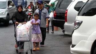 Warga membawa barang belanjaan usai berbelanja di salah satu gerai di kawasan Jakarta Selatan, Jumat (3/1). [Suara.com/Arief Hermawan P]