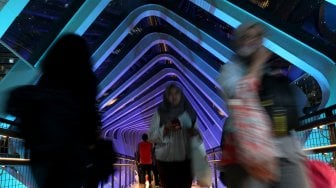 Suasana di Jembatan Penyeberangan Orang (JPO) Gelora Bung Karno (GBK) di Jalan Jendral Sudirman, Jakarta, Jumat (1/3). [Suara.com/Arief Hermawan P]