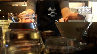 Seorang barista meracik kopi di salah satu kedai kopi di Jakarta, Selasa (5/3). [Suara.com/Arief Hermawan P]