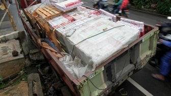 Truk pengangkut batu granit amblas masuk ke dalam lubang saluran air sehingga menutupi sebagian badan jalan di Jalan Pejaten Barat, Pasar Minggu, Jakarta Selatan, Selasa (5/3). [Suara.com/Arief Hermawan P]