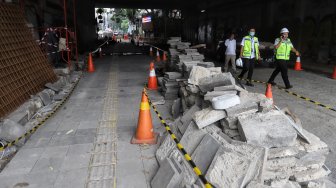 Warga melintas di samping proyek pedestrian Jalan Kendal di bawah Flyover Jalan Sudirman, Dukuh Atas, Jakarta, Selasa (5/3). [Suara.com/Muhaimin A Untung]